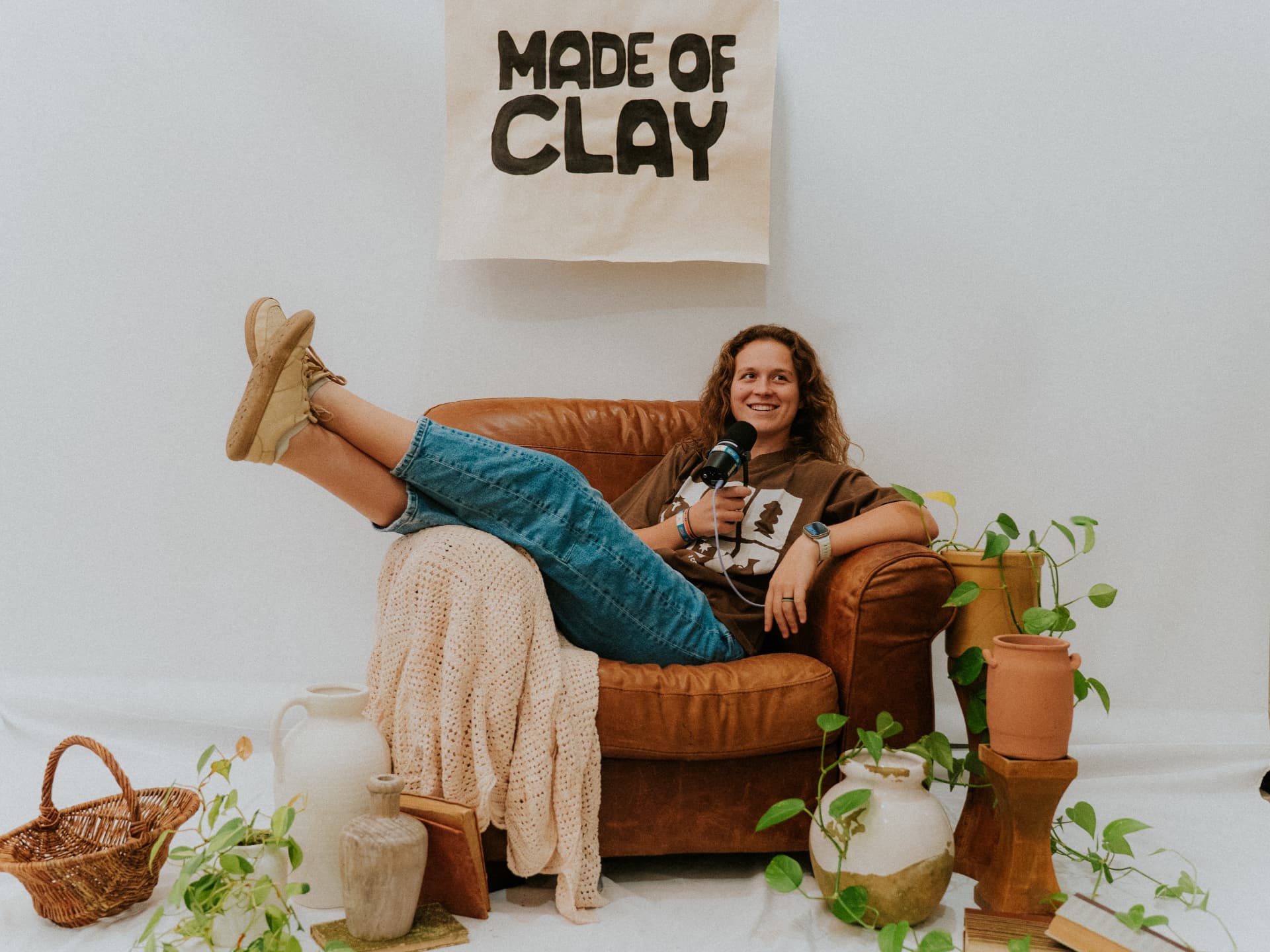 Gabby Gonzales-Heck smiling with a microphone in hand in the Made of Clay studio